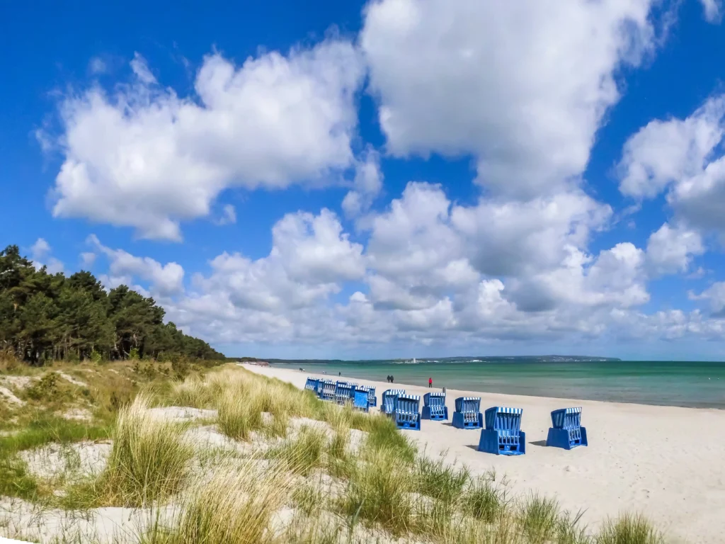 Urlaub mit Hund in Prora auf Rügen – Der perfekte Guide 6 Strand mit weißen Dünen, blauen Strandkörben und Meer bei Prora auf Rügen unter blauem Himmel mit Wolken