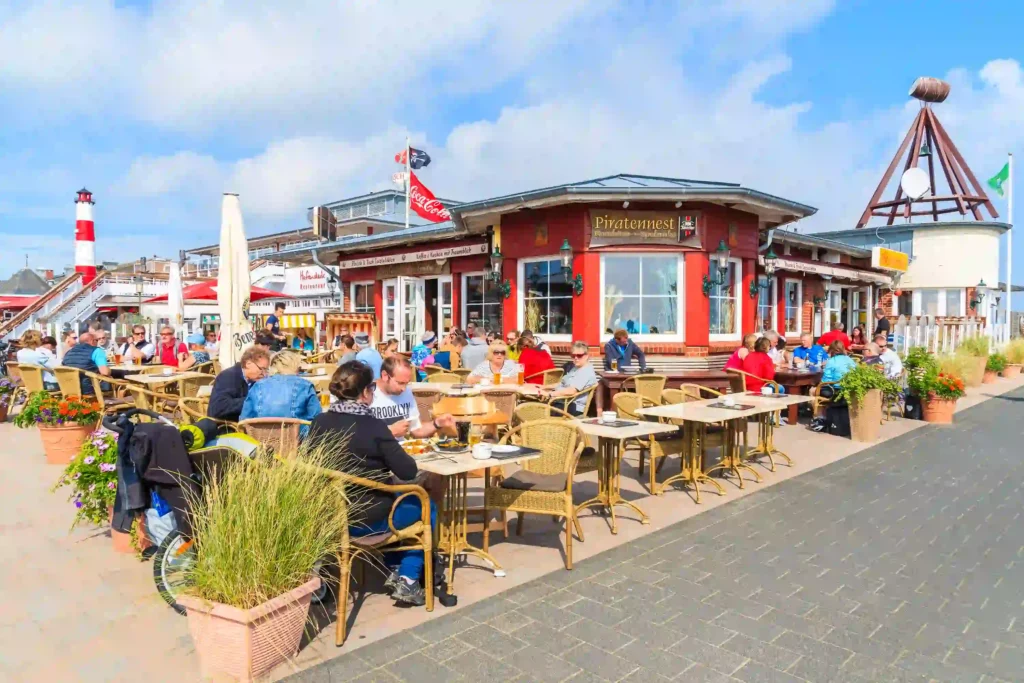 Sylt mit Hund: Dein ultimativer Guide für den perfekten Inselurlaub 9 Belebtes Restaurant "Piratemest" mit Außenterrasse auf Sylt, viele Gäste genießen das sonnige Wetter – auch hundefreundliche Lokale gibt es auf Sylt.