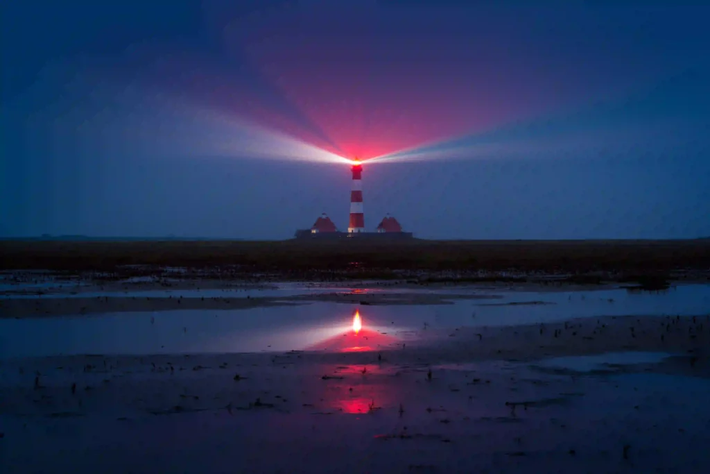 Urlaub mit Hund in St. Peter-Ording: Dein kompletter Guide für entspannte Ferien 7 Der Leuchtturm Westerhever bei Dämmerung mit leuchtendem Licht, nahe St. Peter-Ording.