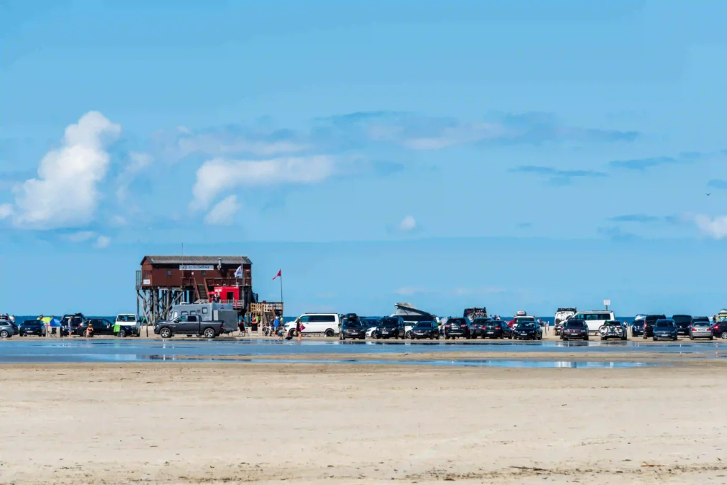 Urlaub mit Hund in St. Peter-Ording: Dein kompletter Guide für entspannte Ferien 5 Strandabschnitt in St. Peter-Ording mit Pfahlbauten und vielen parkenden Autos.