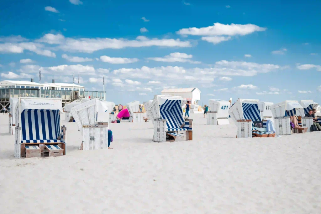 Urlaub mit Hund in St. Peter-Ording: Dein kompletter Guide für entspannte Ferien 2 Zahlreiche Strandkörbe am weitläufigen Sandstrand von St. Peter-Ording unter blauem Himmel.