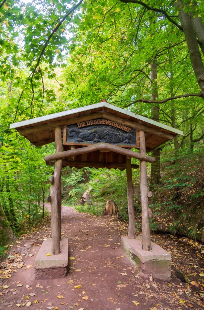 Drachenschlucht bei Eisenach: Abenteuerliche Wanderung mit Hund durch mystische Felsenwelt 1 "Wanderweg durch die Drachenschlucht bei Eisenach mit moosbedeckten Felswänden und Herbstlaub"