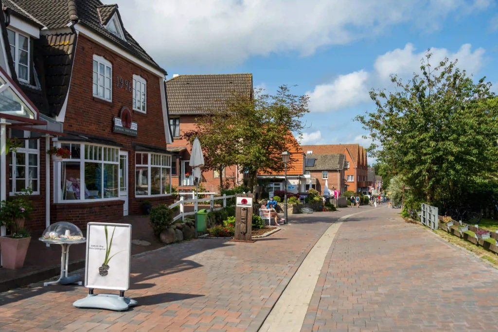 Amrum mit Hund: Perfekter Inselurlaub für Vierbeiner 5 Ruhige Dorfstraße mit Backsteinhäusern und Geschäften, die zum Flanieren in Amrum mit Hund einlädt.