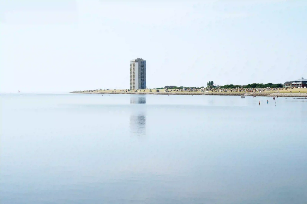 Büsum mit Hund: Perfekter Nordsee-Urlaub mit Vierbeiner 4 Ruhige Nordseelandschaft bei Büsum mit dem Büsumer Hochhaus im Hintergrund, ein friedlicher Ort zum Verweilen und für Strandtage in Büsum, teilweise auch mit Hund.