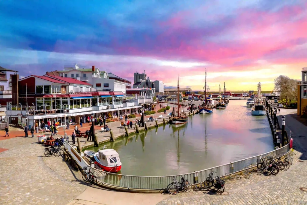 Büsum mit Hund: Perfekter Nordsee-Urlaub mit Vierbeiner 5 Lebhafter Hafenbereich in Büsum bei Sonnenuntergang mit Restaurants und Menschen, ein schöner Ort zum Bummeln und Verweilen in Büsum, auch mit Hund.
