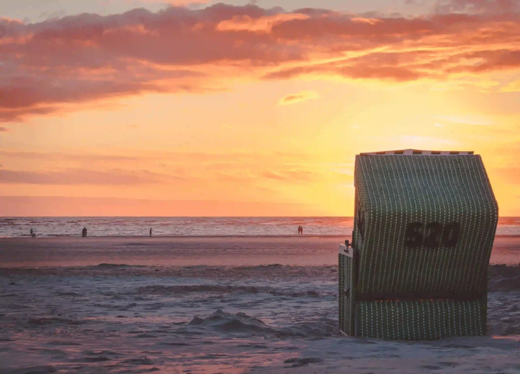 Langeoog mit Hund: dein Perfekter Inselurlaub mit Vierbeiner 9 Sonnenuntergang am Strand von Langeoog mit einem einzelnen Strandkorb, ein wunderschöner Abend für Spaziergänge auf Langeoog mit Hund.