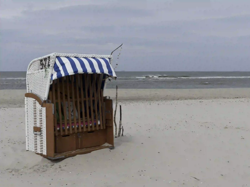 Spiekeroog mit Hund: Tipps für den perfekten Urlaub 2 Strandkorb am ruhigen Strand von Spiekeroog, wo Hunde oft willkommen sind und sich austoben können.