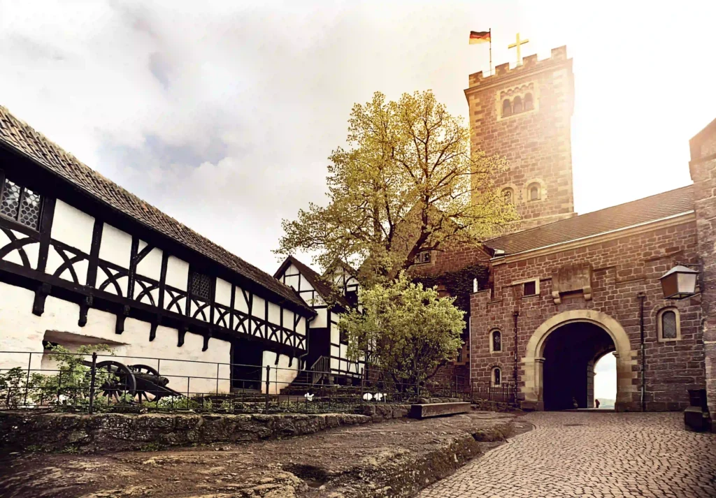 Wartburg mit Hund: Dein perfekter Wanderurlaub im Thüringer Wald 7 Torbogen und Innenbereich der Wartburg mit Fachwerkhäusern im warmen Sonnenlicht, ein Höhepunkt beim Wandern zur Burg.