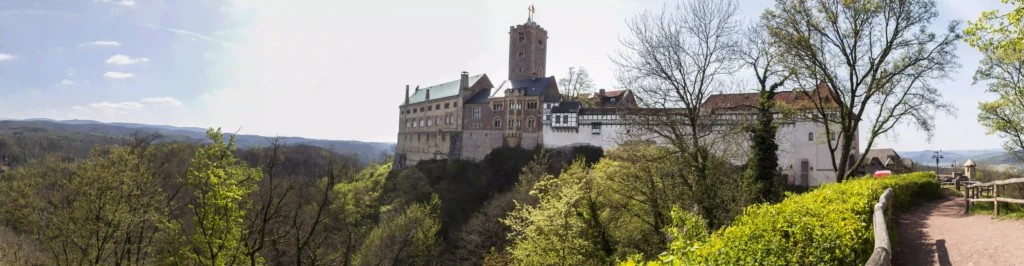 Wartburg mit Hund: Dein perfekter Wanderurlaub im Thüringer Wald 2 Panoramablick auf die Wartburg auf dem Berg, umgeben von weiten Wäldern, ideal für Naturerlebnisse beim Wandern.