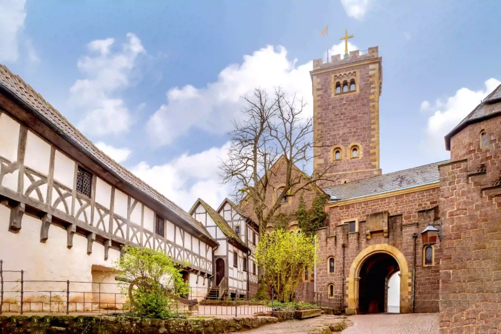 Wartburg mit Hund: Dein perfekter Wanderurlaub im Thüringer Wald 3 Innenhof der Wartburg mit Fachwerkhäusern und dem Bergfried unter blauem Himmel, ideal für Besucher, die die Wartburg erwandern.