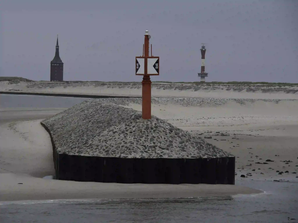 Urlaub auf Wangerooge mit Hund: Dein Guide für perfekte Ferien mit Vierbeiner 6 Wangerooge bei Ebbe, mit Seezeichen und Leuchtturm im Hintergrund, perfekt für einen ruhigen Spaziergang mit Hund.