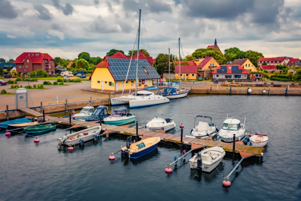 Dranske Ausflugsziele: Perfekter Urlaub mit Hund auf Rügen 5 16 Boote in verschiedenen Farben, darunter weiß, blau und grün, auf dem Wasser bei Dranske an der Ostsee.