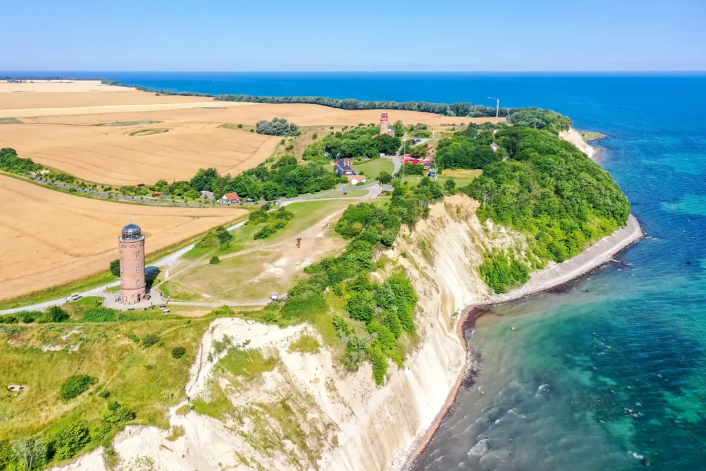 Ausflug Kap Arkona mit Hund: Dein kompletter Guide für Rügen 6 Luftaufnahme von Kap Arkona mit Leuchtturm, weißen Kreidefelsen, goldenen Feldern und klarem blauem Meer am Küstenrand