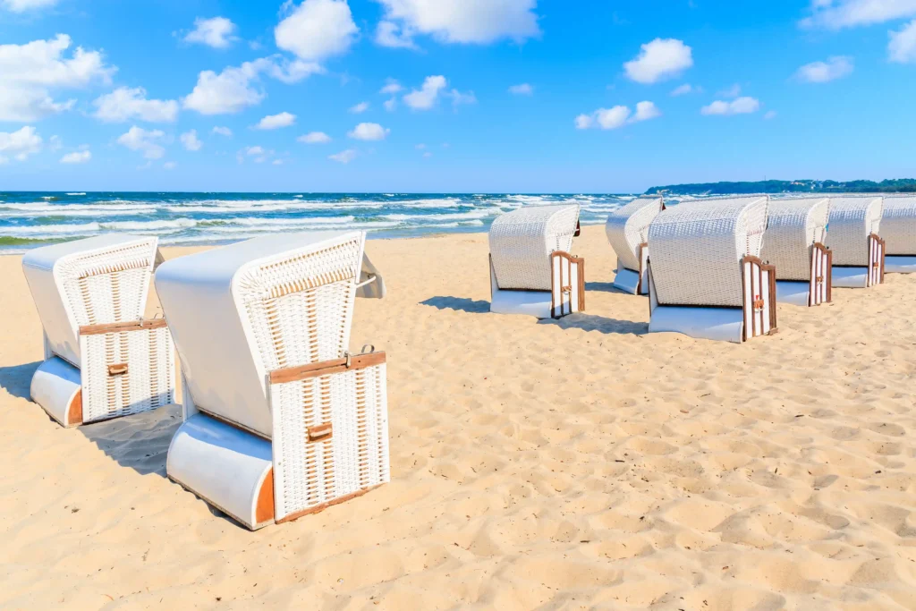Urlaub Göhren mit Hund: Perfekte Ferien auf Rügen 10 Strand mit weißen Strandkörben, goldenem Sand und blauem Meer unter klarem Himmel in Göhren auf Rügen