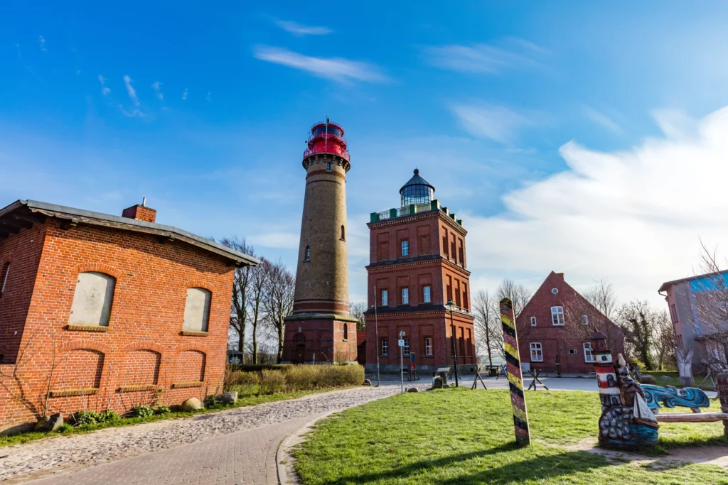 Ausflug Kap Arkona mit Hund: Dein kompletter Guide für Rügen 10 Zwei historische Leuchttürme und Gebäude am sonnigen Kap Arkona mit blauem Himmel und gepflegtem Weg im Vordergrund