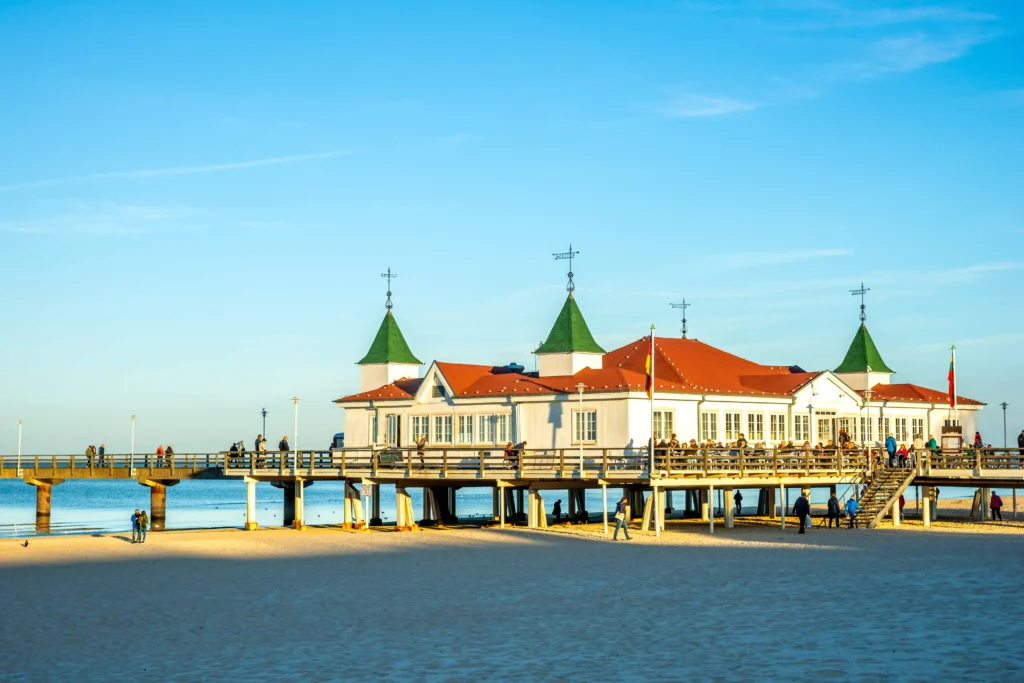 Ferien mit Hund im Seebad Ahlbeck – Entspannung pur 20 Pier mit rotdachigem Gebäude, Strand und Meer bei blauem Himmel – ideal für Ferien mit Hund in Ahlbeck.