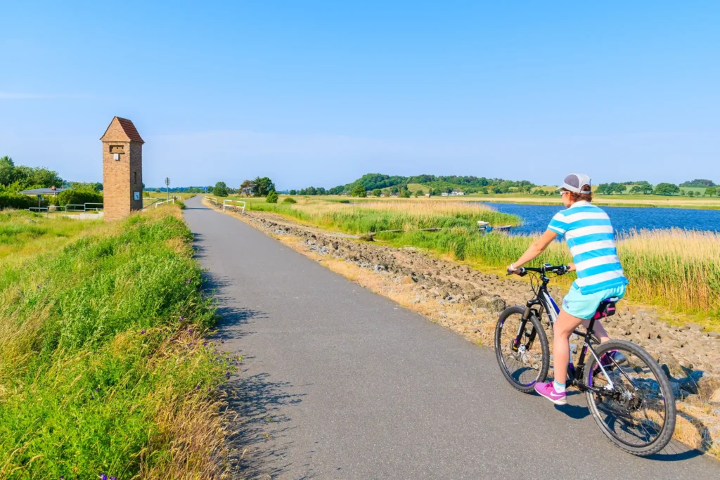 Urlaub mit Hund in Baabe auf Rügen: Top Tipps & Guide 5 Person auf Fahrrad vor Gebäude in Baabe Rügen, idyllische Szene mit Radfahren und typischer Architektur im Hintergrund