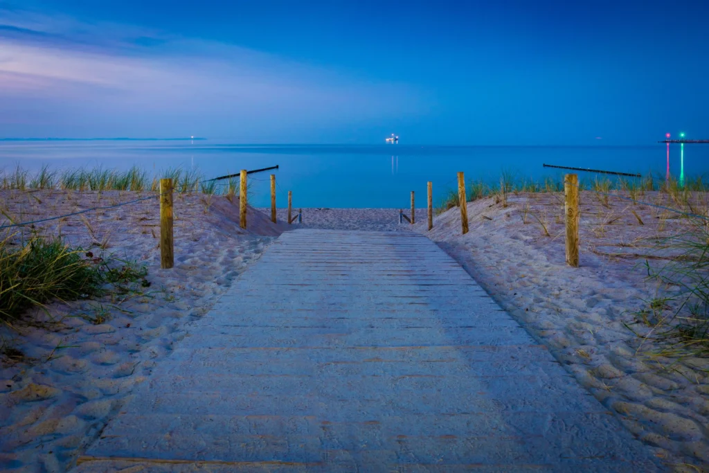 Glowe auf Rügen: Perfekter Urlaub mit Hund 6 Holzsteg am Strand bei Dämmerung mit Dünen und ruhigem Wasser – perfektes urlaug in glowe rügen Erlebnis