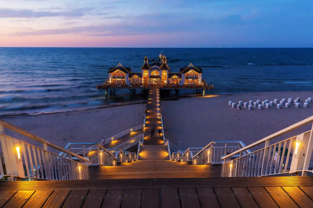 Rügen mit Hund: Perfekter Urlaub für dich & deinen Vierbeiner 16 Beleuchteter Pier bei Dämmerung mit Strandkörben am Meer – perfekter Ort für Rügen mit Hund entdecken