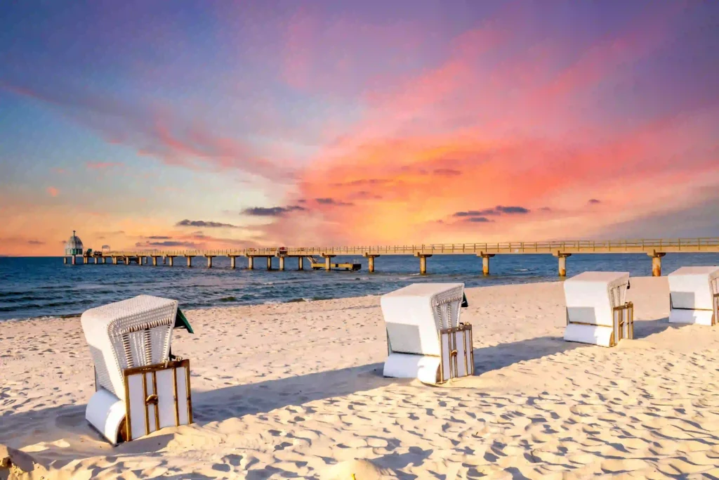Urlaub mit Hund in Zinnowitz: Dein perfekter Ostseeurlaub 7 Strand mit Strandkörben und Pier bei Sonnenuntergang in Zinnowitz mit Hund, ruhige Ostseeküste und bunter Himmel